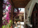 Pretty bougainvillea and stone arches lend to the character of this addorable property