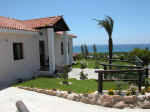 The villa has a large enclosed garden and a covered parking area.
